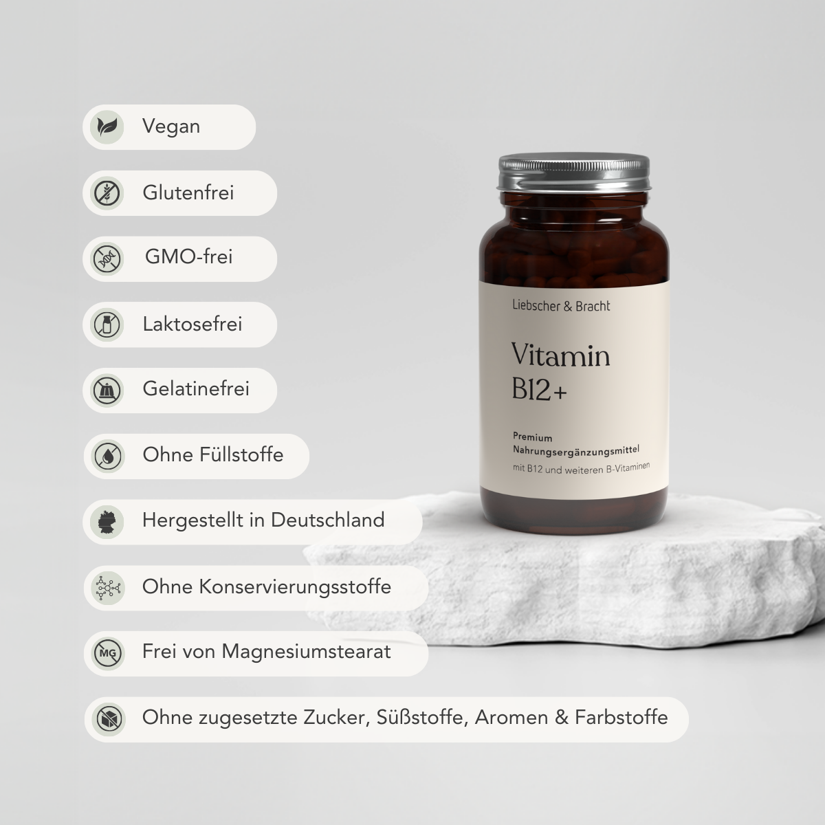 Auf einer weißen Steinplatte steht eine Braunglasflasche von Liebscher & Bracht Vitamin B12+ für 4 Monate, gekennzeichnet als vegan mit B-Vitaminen zur Unterstützung des Immunsystems. Frei von Gluten, GMO, Laktose, Gelatine, Füllstoffen und Konservierungsstoffen. Hergestellt in Deutschland.
