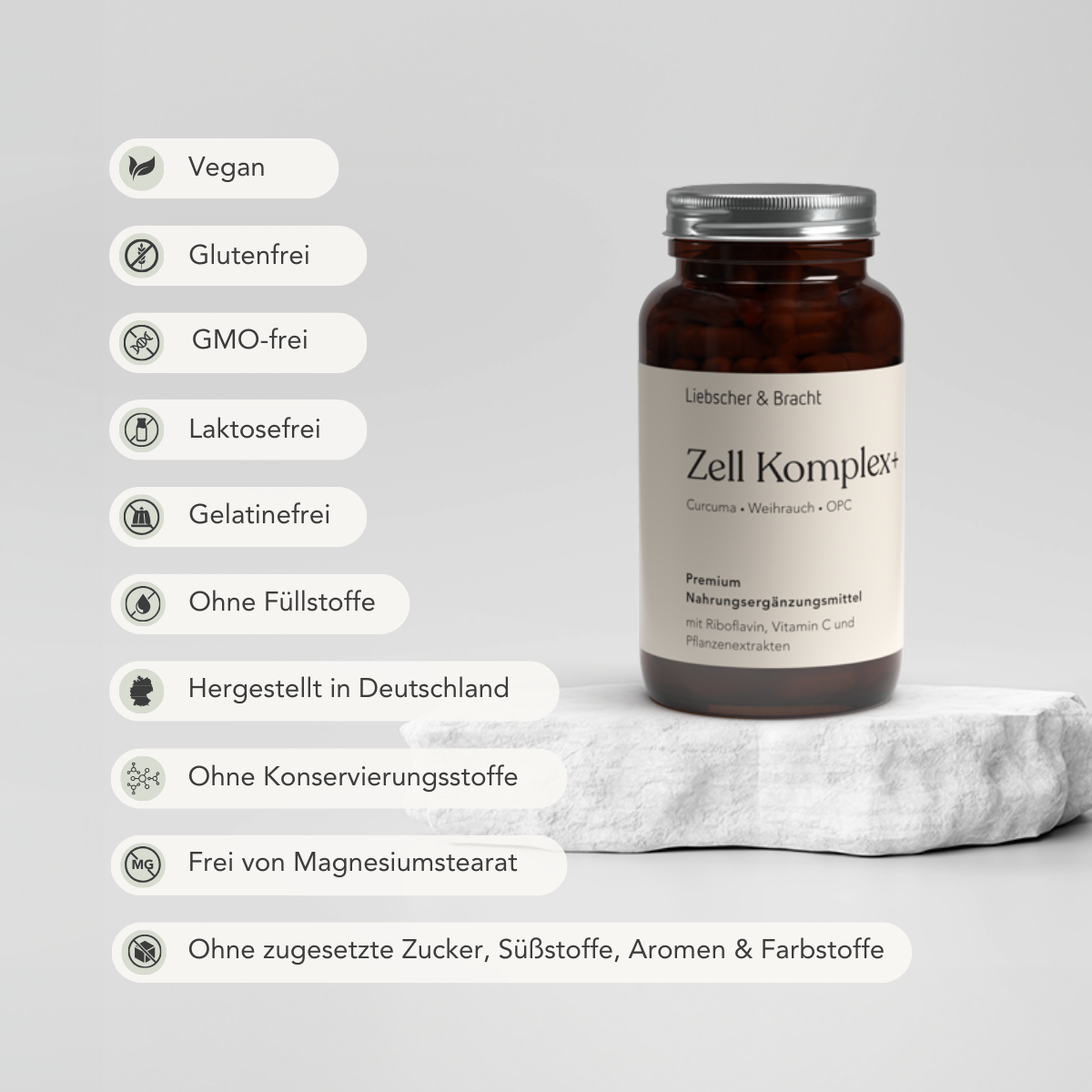 Eine braune Flasche mit der Aufschrift Zell Komplex+ für 2 Monate von Liebscher & Bracht steht auf einem Stein. Icons zeigen, dass es vegan, glutenfrei, gentechnikfrei, mit Riboflavin (B2), Traubenkern-Extrakt (OPC), made in Germany und frei von Konservierungsstoffen oder Zuckerzusatz ist.