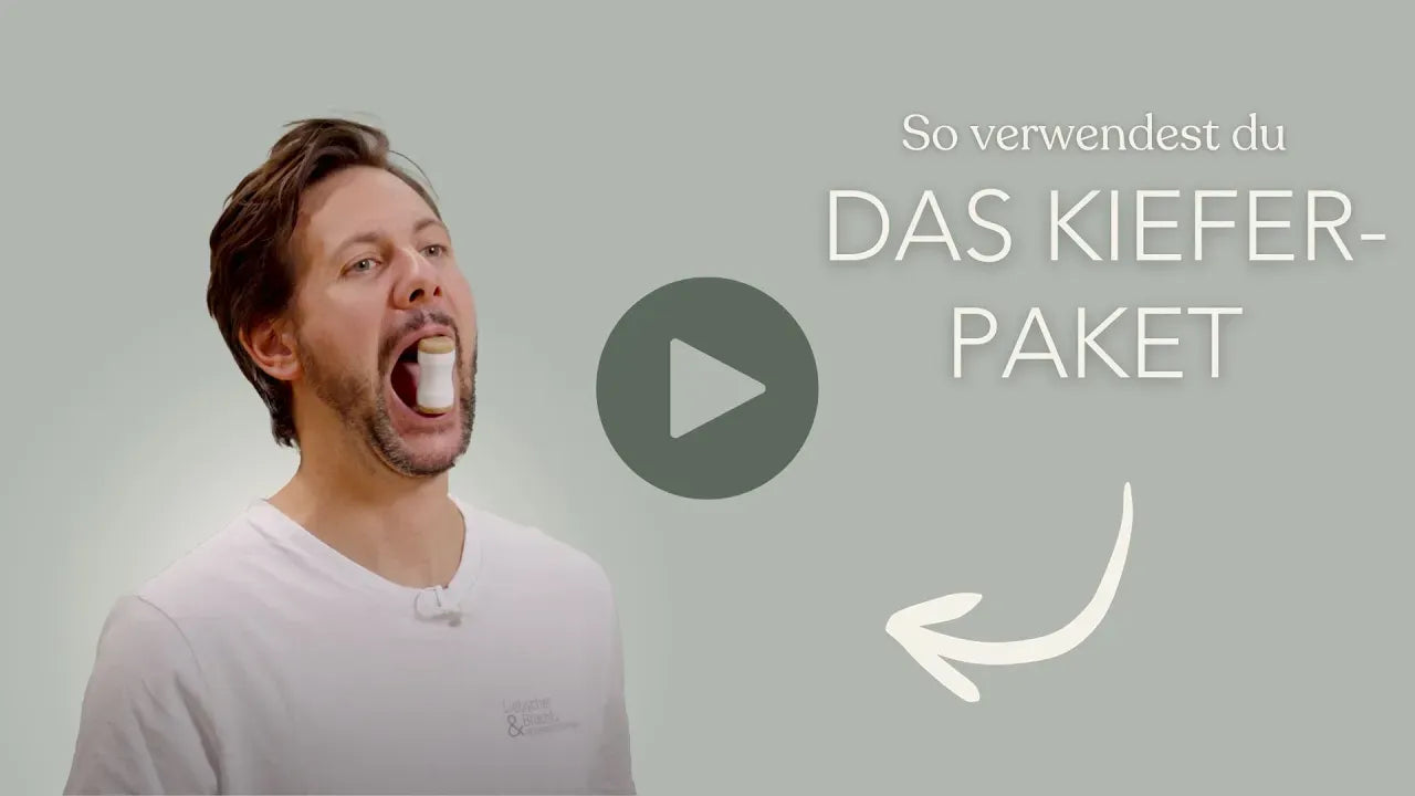 Ein Mann in einem weißen Hemd demonstriert, wie man ein Mundgerät benutzt, indem er seinen Mund aufreißt. Der deutsche Text lautet "So verwendest du das Kieferpaket" mit einer Abspieltaste und einem Pfeil.