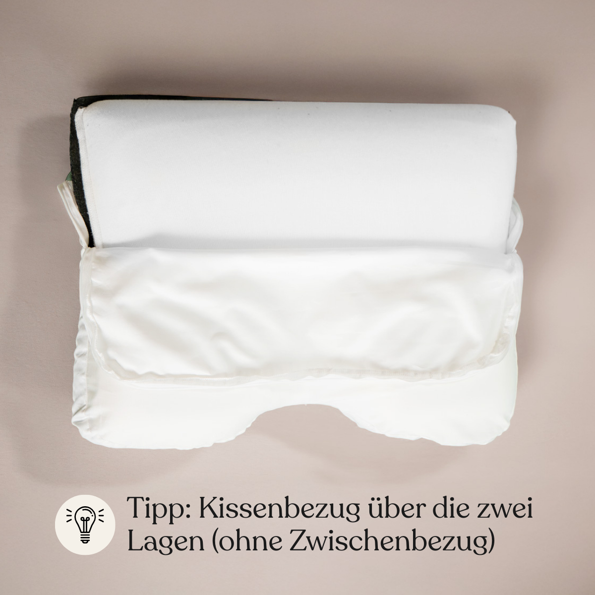 Abgebildet ist ein weißes Kissen mit zwei Lagen, von denen eine teilweise von einem Liebscher & Bracht 2er-Pack bedeckt ist: Baumwoll-Kissenbezug. Am unteren Rand steht ein deutscher Text: Tipp: Kissenbezug über die zwei Lagen (ohne Zwischenbezug).