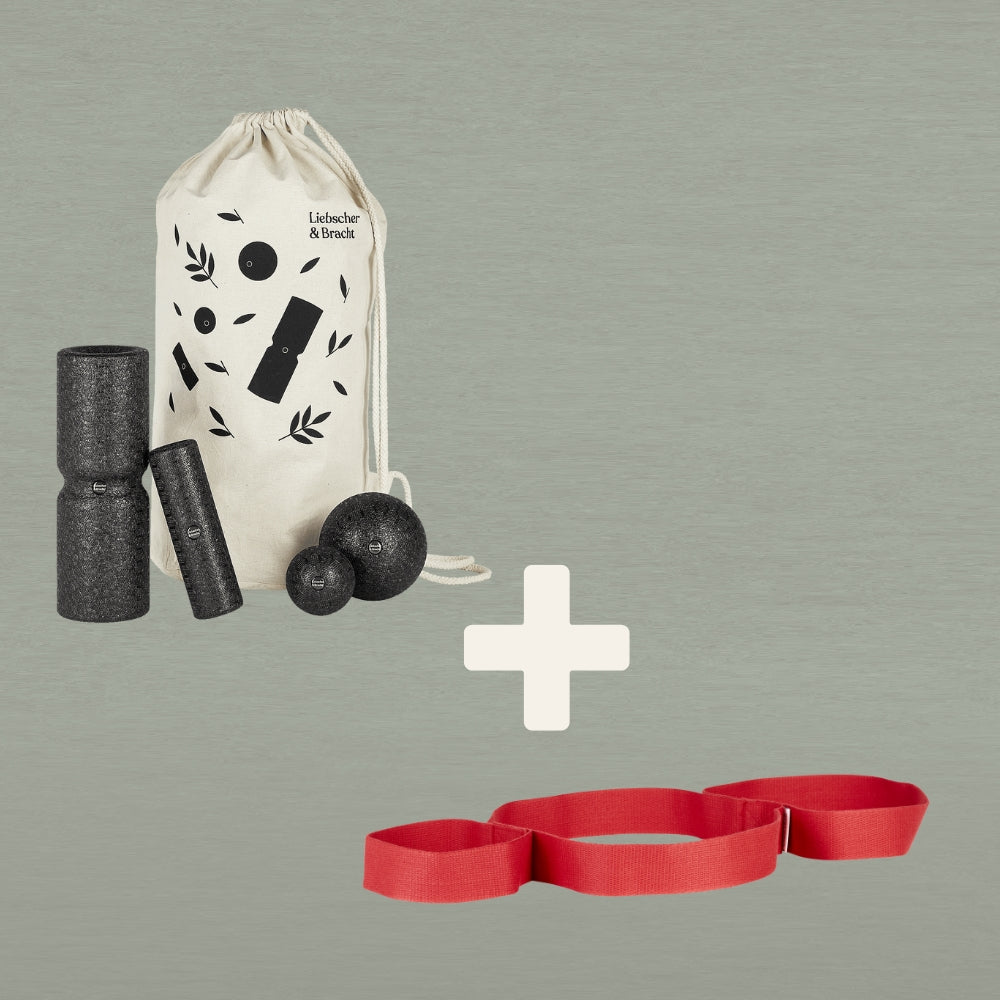 Das Liebscher & Bracht "Unsere Empfehlung | Faszien-Set + Übungs-Schlaufe" zeigt einen cremefarbenen Beutel mit Faszienrollen und Massagebällen über einem roten Band für Dehnübungen, getrennt durch ein großes Plus auf grauem Hintergrund.