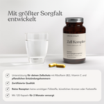 Eine braune Liebscher & Bracht-Flasche mit der Aufschrift "Zell Komplex+ für 2 Monate" steht neben einem Glas Wasser und zwei gelben Kapseln. Der deutsche Text verweist auf Zellschutz mit Traubenkern-Extrakt (OPC), geprüfte Qualität und einen Vorrat für 2 Monate.