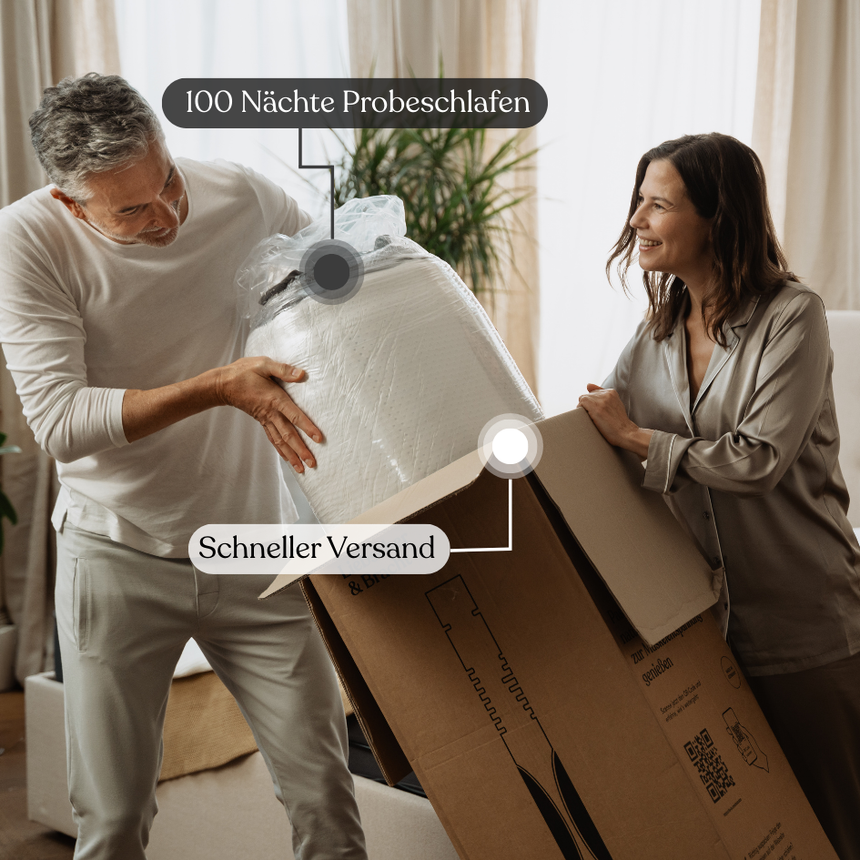 Ein lächelndes Paar packt das Liebscher & Bracht Schlafset aus: Matratze + Kissen in einem gemütlichen Wohnzimmer aus. Text auf dem Bild: 100 Nächte Probeschlafen und Schneller Versand.