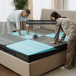 Ein Mann und eine Frau drücken auf die freigelegten Schichten eines Liebscher & Bracht Schlafsets: Matratze + Kissen in einem modernen Schlafzimmer. Der Text "Etwas festerer Stützkern" weist auf den etwas festeren Stützkern hin.