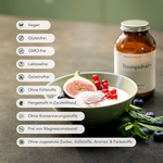 Eine Schale Joghurt mit Feigen, roten Johannisbeeren und dem vitamin- und eisenreichen ALL IN ONE - Basispulver von Liebscher & Bracht steht neben dem braunen Glas. Die Symbole zeigen, dass er vegan, glutenfrei, gentechnikfrei, laktosefrei, ohne Zuckerzusatz und ohne Zusatzstoffe ist.