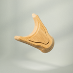 Der Holz-Sockel für den Nackenretter von Liebscher & Bracht ist ein glattes, leichtes Holzaccessoire mit einer modernen, abstrakten Wünschelrutenform, die elegant vor einem neutralen Hintergrund schwebt.