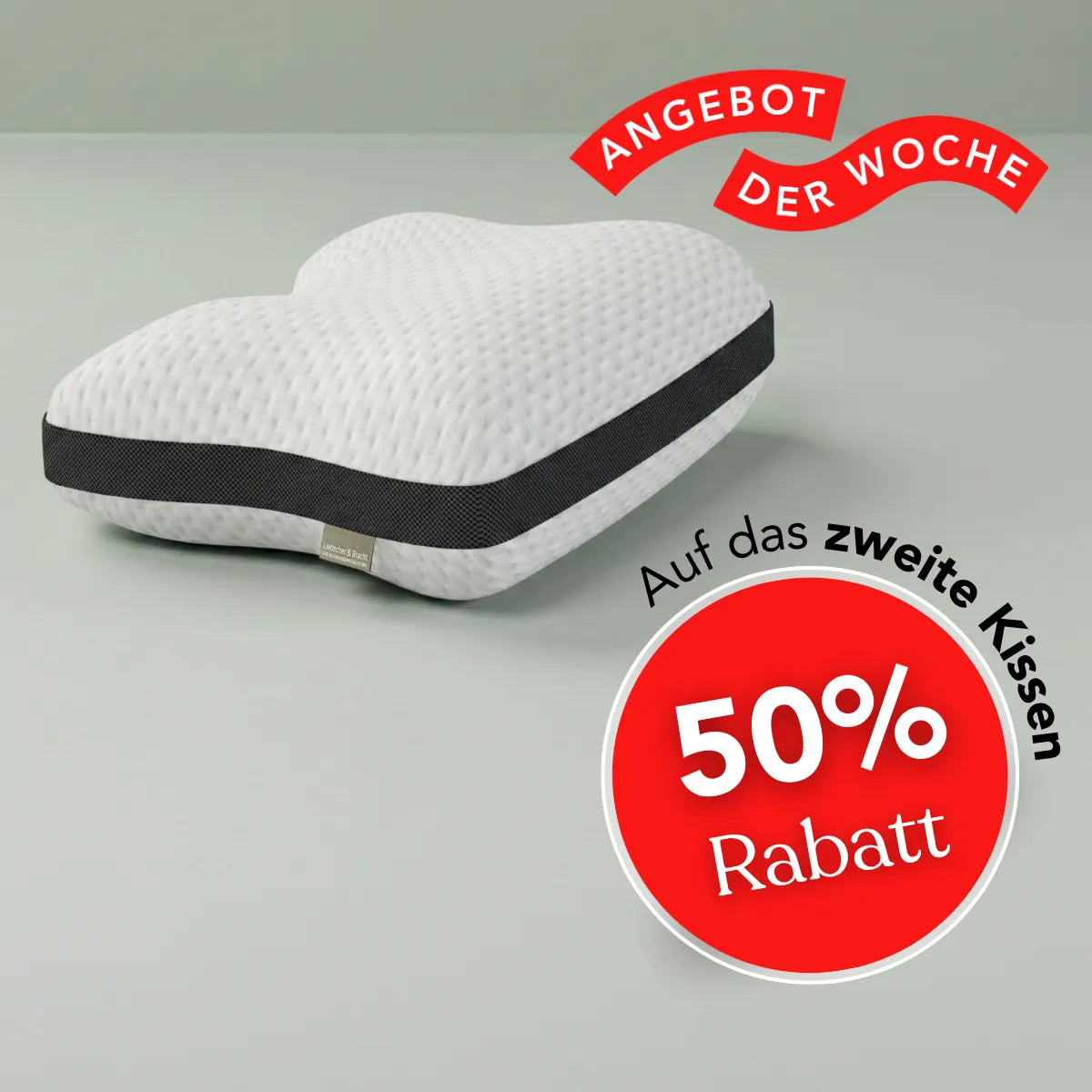 Ein weißes, herzförmiges Liebscher & Bracht-Kissen mit einem schwarzen Streifen – ideal für bequemen Halt in Rückenlage – ist neben einem roten Kreis zu sehen, der einen Rabatt von 50 % auf das zweite Kissen hervorhebt. Auf einem roten Banner steht „Angebot der Woche“. Perfekt als Liebscher & Bracht-Kissen!.
