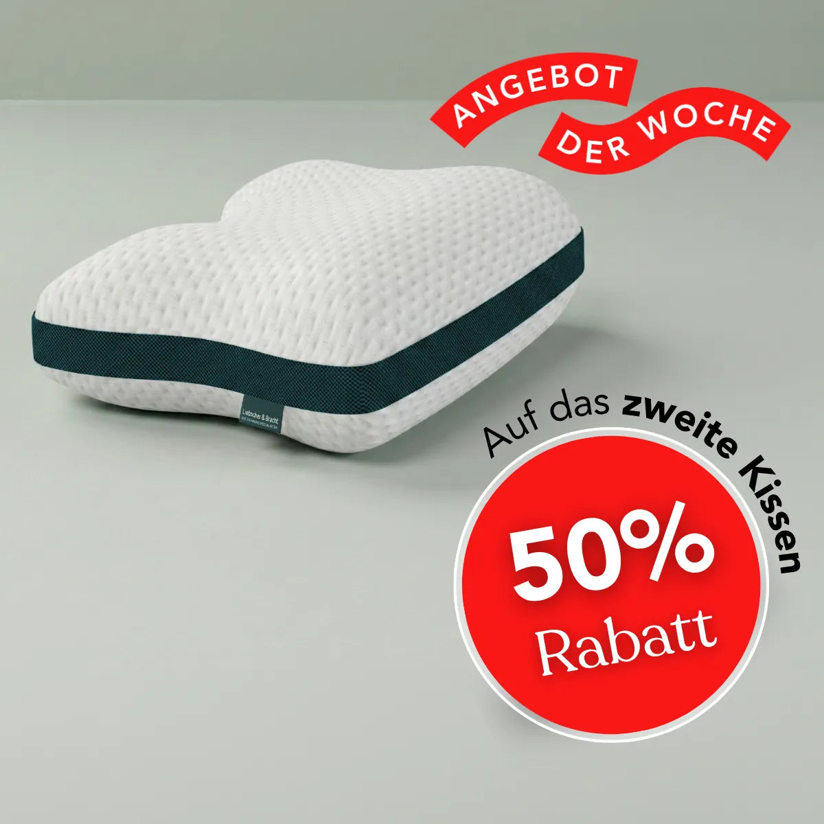 Das Liebscher & Bracht-Kissen „Clean+“ liegt auf einer grauen Unterlage. Rote Banner mit den Aufschriften „Angebot der Woche“ und „50 % Rabatt auf das zweite Kissen“ kennzeichnen das Wochenangebot. Das Kissen „Clean+“ eignet sich ideal für verschiedene Schlafpositionen und bietet insbesondere in Rückenlage optimalen Komfort.