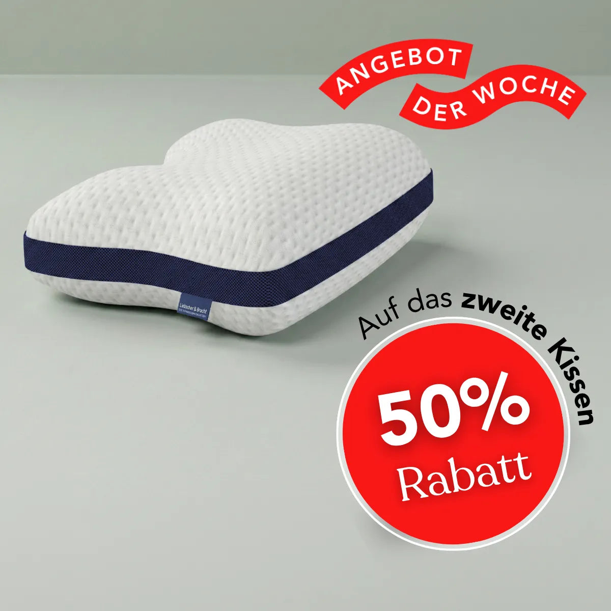 Herzförmiges weißes Kissen „Cool+“ von Liebscher & Bracht mit dunkelblauer Einfassung auf grauem Hintergrund. Dieses Kissen bietet optimale Unterstützung für verschiedene Schlafpositionen, insbesondere in Rückenlage. Auf einem roten Aufnäher steht „50 % Rabatt“ auf das zweite Kissen, und ein rotes Band darüber trägt die Aufschrift „Angebot der Woche“.