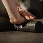 Nahaufnahme einer Person, die das Faszien-Rollmassage-Set von Liebscher & Bracht am Unterarm anwendet, während sie auf einer Matte sitzt – zur Muskelmassage, zur Entspannung oder zur Verbesserung der Beweglichkeit im Rahmen einer Physiotherapie.