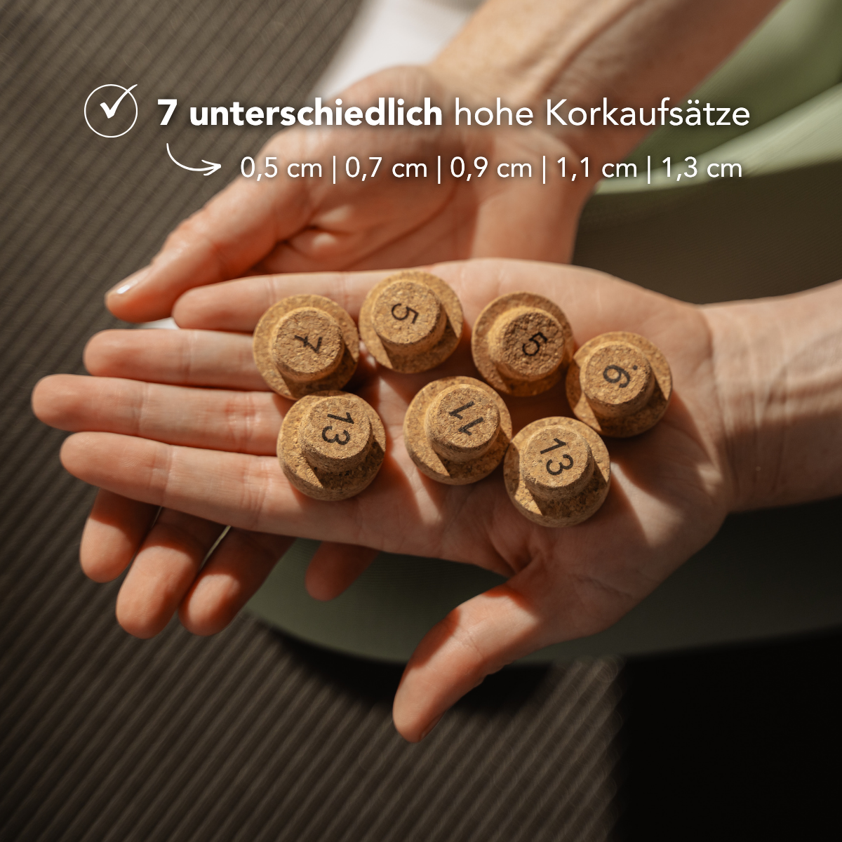 Eine Person hält sieben runde „Der Kieferretter“-Korkstopfen von Liebscher & Bracht (0,5–1,3 cm hoch) in der Hand, die sich ideal zur Linderung von Kieferschmerzen oder Zähneknirschen bei CMD-Symptomen eignen. Der deutsche Text oben beschreibt die Produkteigenschaften.