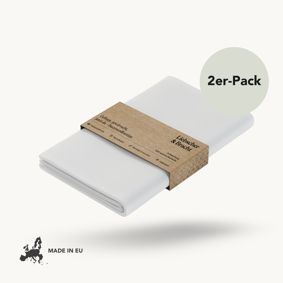 Zwei gefaltete weiße Liebscher & Bracht Baumwoll-Kissenbezüge, gebündelt mit einem Kraftpapierband mit der Aufschrift "2er-Pack: Baumwoll-Kissenbezug". Ein kleines Kartensymbol mit "MADE IN EU" erscheint unten links auf weißem Hintergrund.