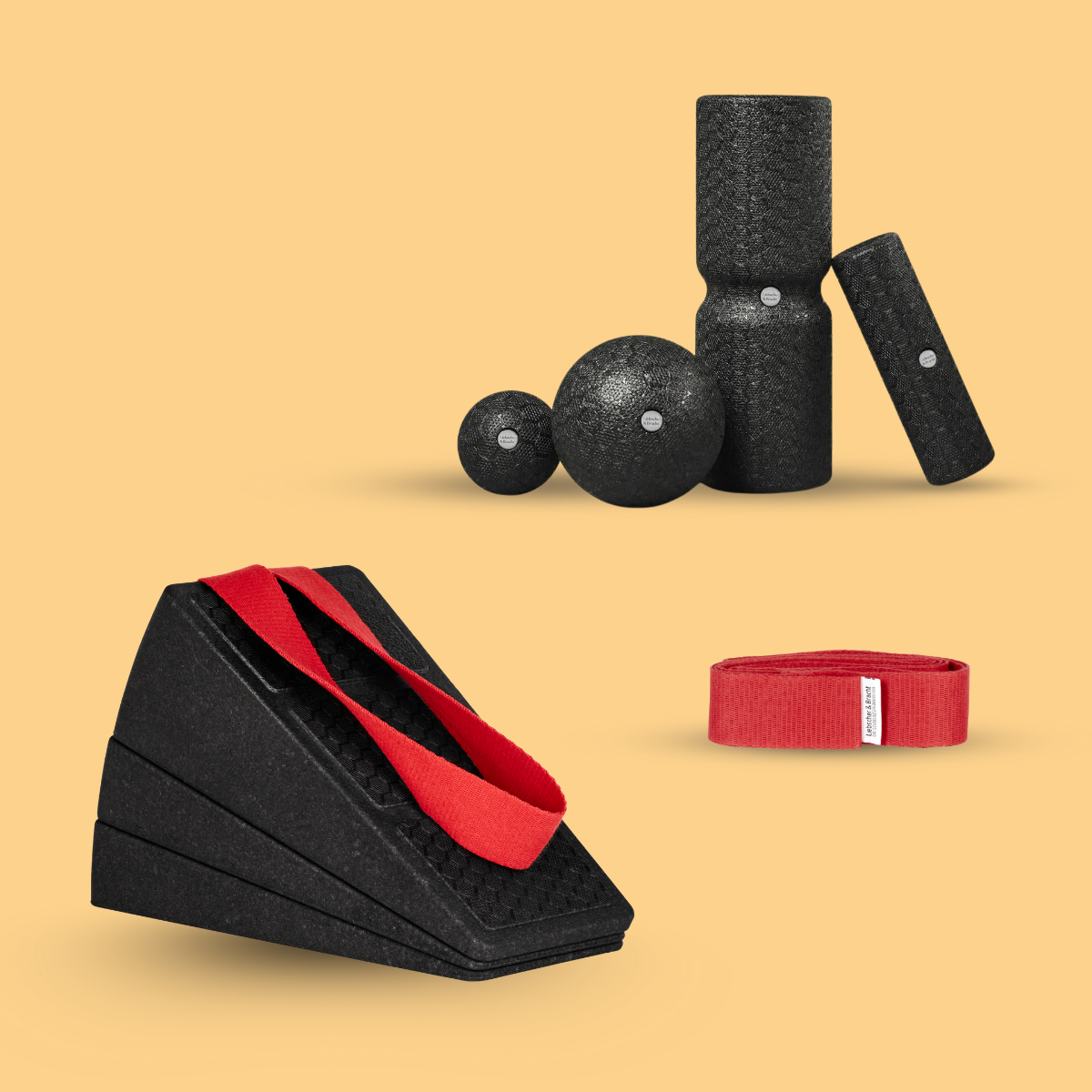 Das Liebscher & Bracht Dein Knie-Paket enthält schwarze Schaumstoff-Fitnessrequisiten - Faszienrollen, Keile, Massagebälle und eine rote Trittschlaufe -, die auf einem hellbraunen Hintergrund präsentiert werden.