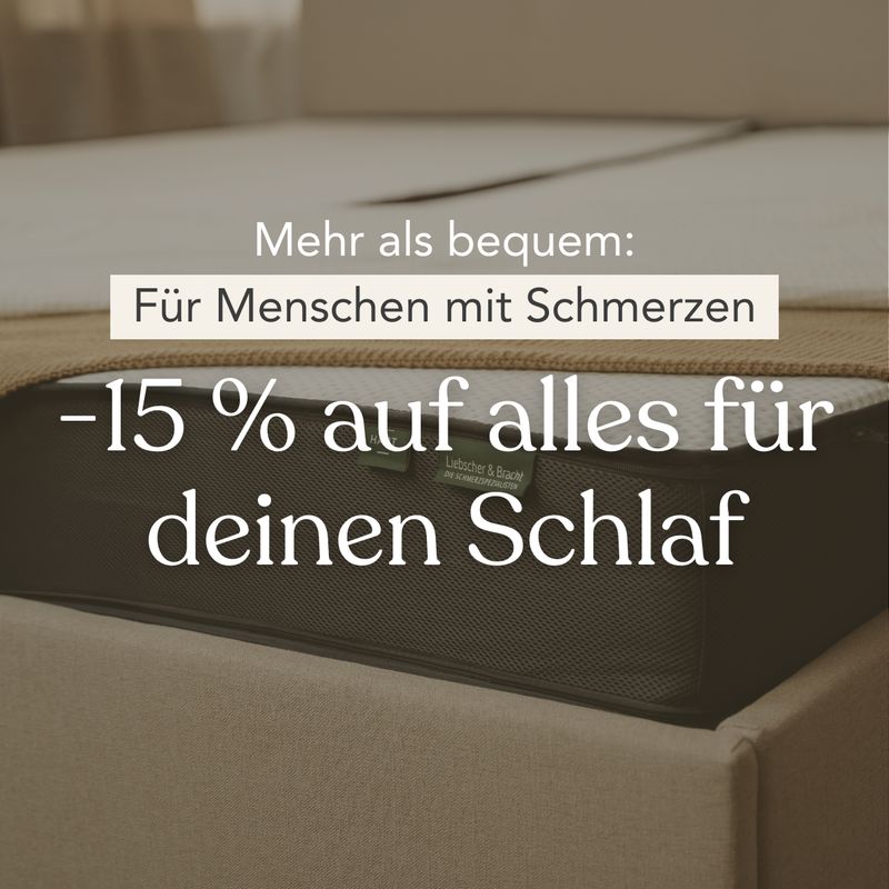Nahaufnahme eines Bettes mit einem Text in deutscher Sprache, in dem ein Rabatt von 15 % auf alle schlafbezogenen Produkte, insbesondere für Menschen mit Schmerzen, angeboten wird. Der Hintergrund zeigt einen Teil einer Matratze und Bettzeug in einem schwach beleuchteten Raum.