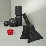 Ein Satz schwarzer, strukturierter Schaumstoff-Massagewerkzeuge aus dem Liebscher & Bracht Dein Nacken-Paket - Rollen, Bälle, keilförmige Blöcke - sind auf einer hellgrauen Fläche angeordnet, mit einem roten Übungs-Schlaufe-Übungsband im Vordergrund.