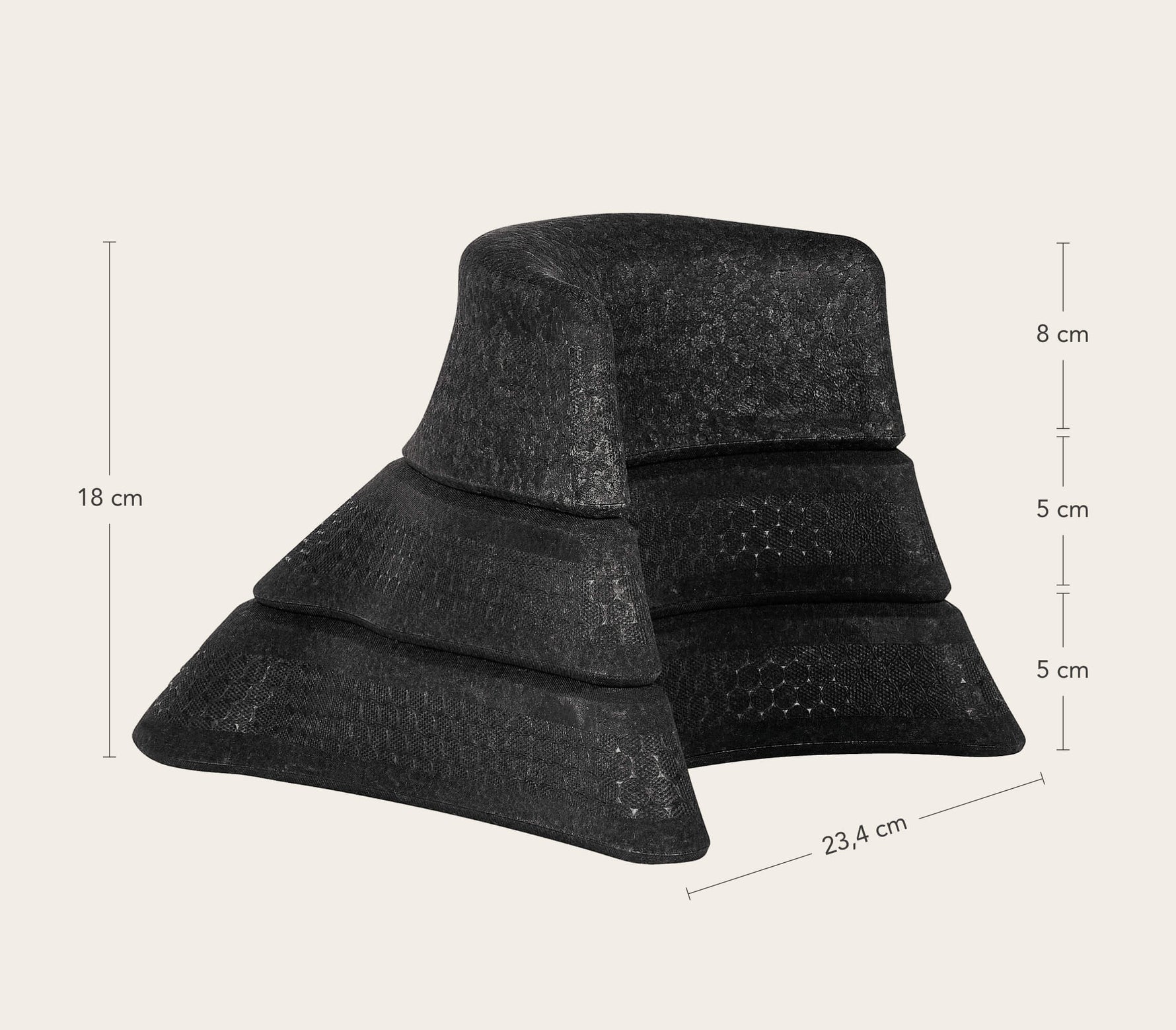 Ein schwarzes, dreistufiges, keilförmiges Objekt mit folgenden Abmessungen: 18 cm hoch, jede Stufe misst 8 cm, 5 cm und 5 cm; die Basisbreite beträgt 23,4 cm. Das Objekt hat eine strukturierte, netzartige Oberfläche.