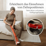 Eine Frau nutzt ein orangefarbenes Widerstandsband aus dem Dein Rücken-Paket zum Dehnen auf einem Bett; eine Einblendung zeigt eine Nahaufnahme des Bandes in ihrer Hand während einer Übung aus dem Faszien-Set.