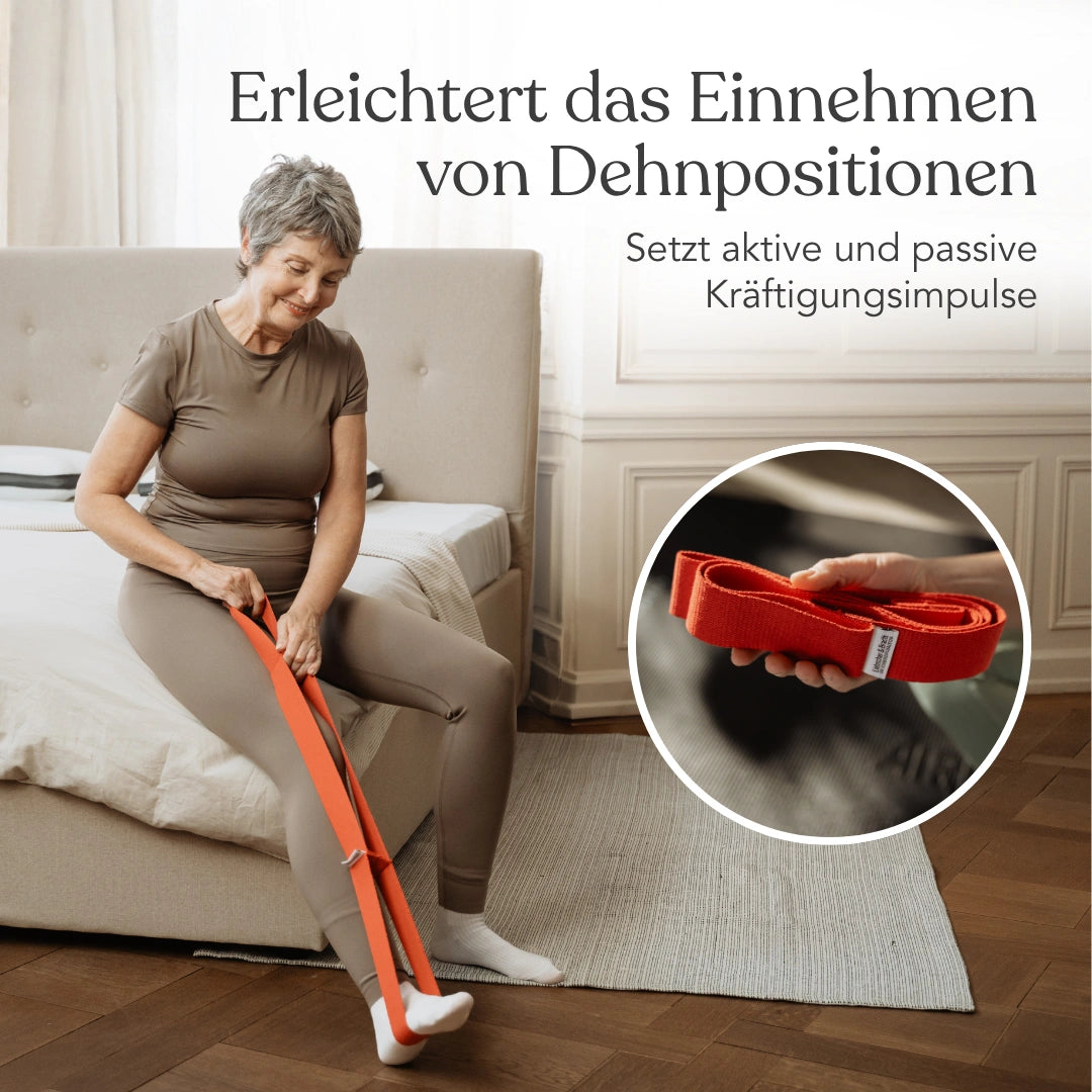 Eine Frau nutzt ein orangefarbenes Widerstandsband aus dem Dein Rücken-Paket zum Dehnen auf einem Bett; eine Einblendung zeigt eine Nahaufnahme des Bandes in ihrer Hand während einer Übung aus dem Faszien-Set.