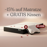 Eine wendbare Matratze von Liebscher & Bracht mit weißem Bezug und roten Rosenblättern liegt vor zartrosa Hintergrund. Text: "-15% auf Matratze + GRATIS Kissen", durchgestrichener Preis 99,00€.