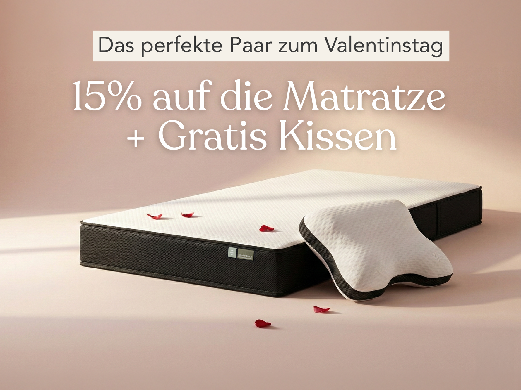 Eine Matratze und ein Kissen liegen auf einem hellen Boden mit verstreuten roten Rosenblättern. Ein Text in deutscher Sprache wirbt für ein Valentinstagsangebot: 15% auf die Matratze + Gratis Kissen (15% Rabatt auf die Matratze + Gratis Kissen).