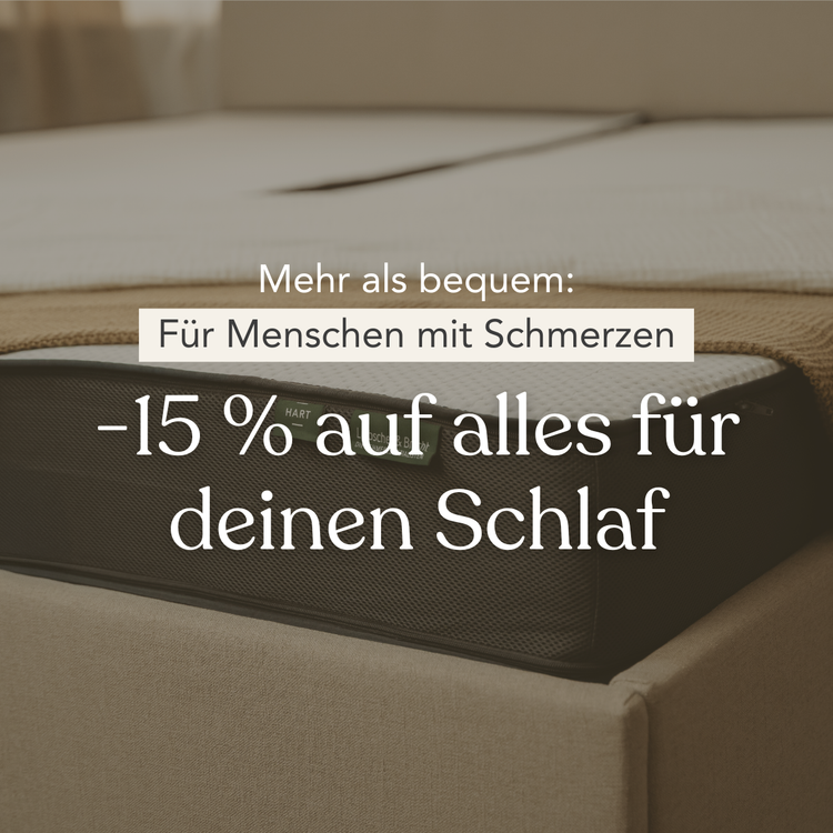 Ein Bett mit einer Matratze ist in einem schwach beleuchteten Raum zu sehen. Der überlagerte deutsche Text lautet: Mehr als bequem: Für Menschen mit Schmerzen -15 % auf alles für deinen Schlaf.