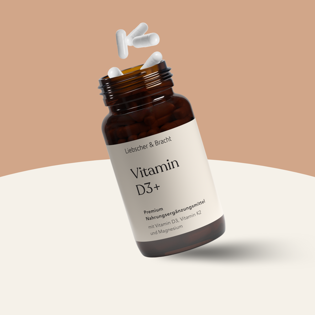 Eine braune Flasche Liebscher & Bracht Vitamin D3 + K2 / 2000 I.E., mit weißen Kapseln, die aus dem geöffneten Deckel fliegen, vor einem hellbeigen und weißen Hintergrund. Das Etikett hebt den Zusatz von Vitamin K2 und Magnesium zur Unterstützung des Immunsystems hervor.