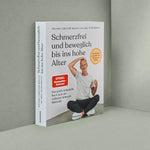 Ein deutsches Buch mit dem Titel "Schmerzfrei und beweglich bis ins hohe Alter" von Liebscher & Bracht steht aufrecht auf einer grauen Fläche. Sein Umschlag zeigt einen lächelnden Mann im Schneidersitz, der Übungen zur Schmerzlinderung und Beweglichkeit anpreist.