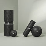 Das Liebscher & Bracht Faszien-Rollmassage-Set besteht aus vier schwarzen Massagerollen und -kugeln in verschiedenen Formen und Größen mit weißer Mittelmarkierung, die auf einer hellgrauen Oberfläche abgebildet sind - ideal zur Entspannung und Verbesserung der Beweglichkeit.