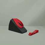 Ein Liebscher & Bracht Knieretter-Set, bestehend aus zwei schwarzen Schaumstoff-Knieretter-Keilen mit einer roten Übungs-Schlaufe darauf und einer weiteren roten Übungs-Schlaufe daneben, wird vor einem schlichten hellgrauen Hintergrund präsentiert.