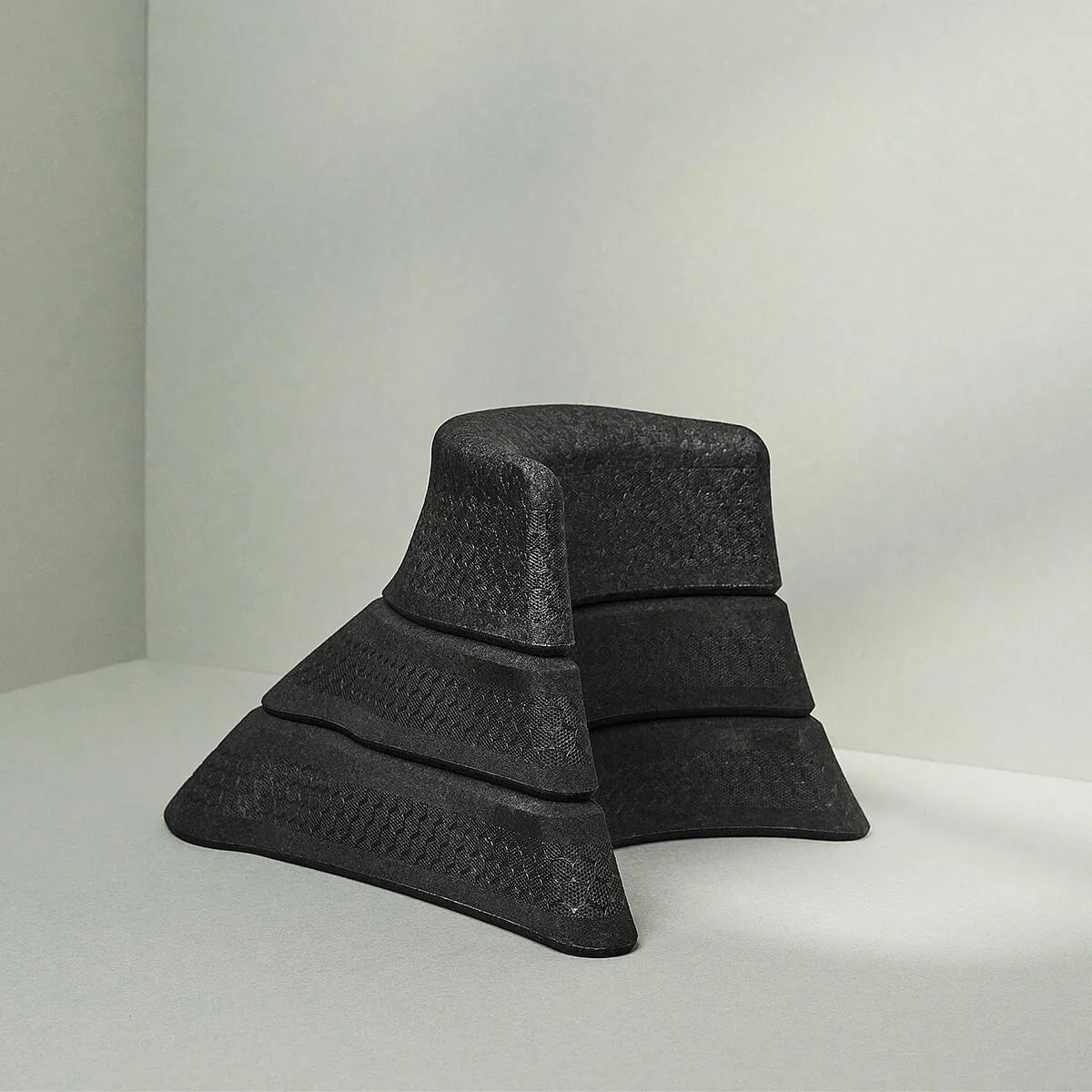 Der Nackenretter von Liebscher & Bracht, ein moderner, schwarzer Stuhl mit geometrischem Design, bietet dank seiner strukturierten Flächen und breiten Basis ideale Unterstützung für Dehnungs- oder Entspannungsübungen.