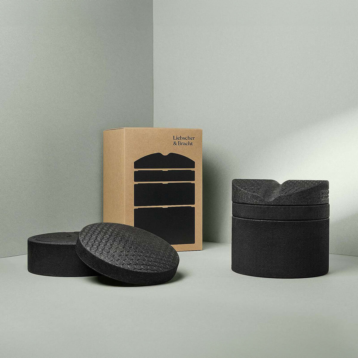 Der Rückenretter von Liebscher & Bracht: Drei schwarze, strukturierte Schaumstoff-Massage-Tools zur Entspannung und Mobilisierung der Rückenmuskulatur in braun-schwarzer Box auf hellgrauem Untergrund.