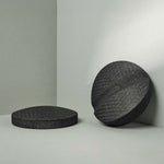 Zwei runde, dunkelgraue Der Rückenretter-Kugeln von Liebscher & Bracht liegen auf einer hellgrauen Fläche - eine flach, eine aufrecht in der Ecke - und eignen sich perfekt zur Entspannung und Mobilisierung der Rückenmuskulatur.